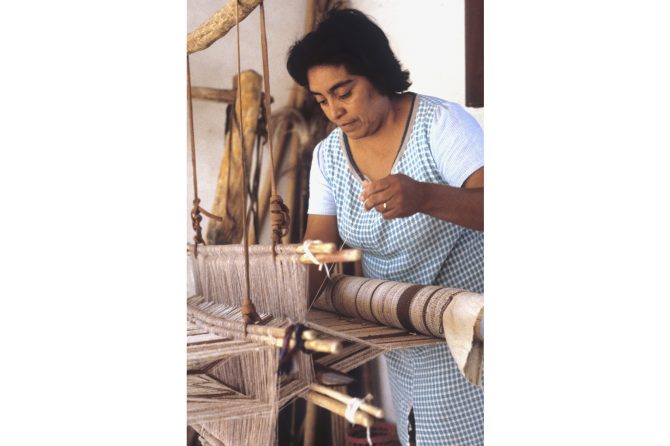 A local community woman weaving camelid fiber on a loom