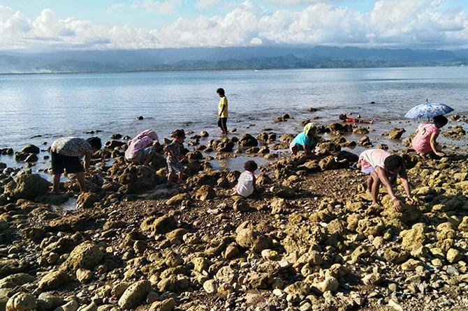 Agta women and children gather shells and other marine products on intertidal reefs of Dumaguipo tribal settlement in Casiguran, Aurora Province.